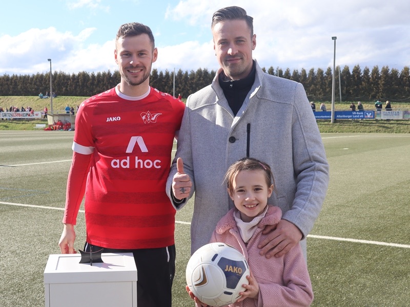 Sebastian Boge mit einem Spieler des SV Schmölln und seiner Tochter beim Sponsorenbild am Spieltag.
